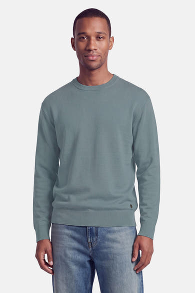 Pull col rond bleu clair de la marque INDIGOLD, en maille douce, porté avec un jean délavé, vue de face.