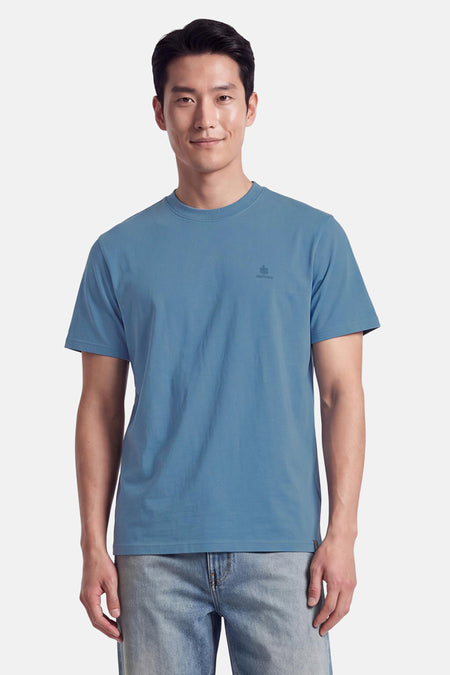 T-shirt bleu à manches courtes par INDIGOLD, col rond, logo discret sur la poitrine, porté avec jeans délavés, vue de face.