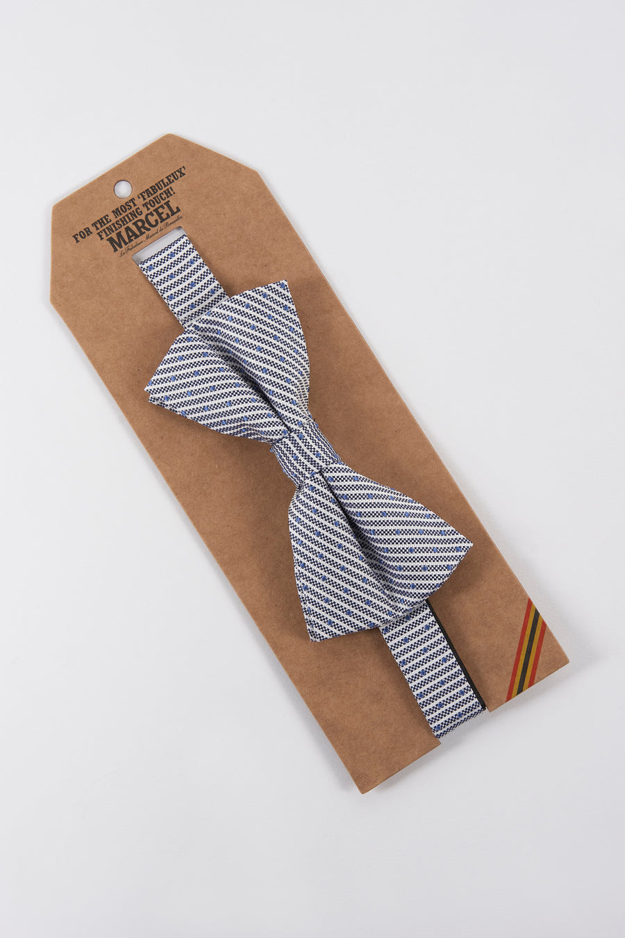 Nœud papillon bleu à motifs, de Le Fabuleux Marcel de Bruxelles, sur son carton d'emballage.
