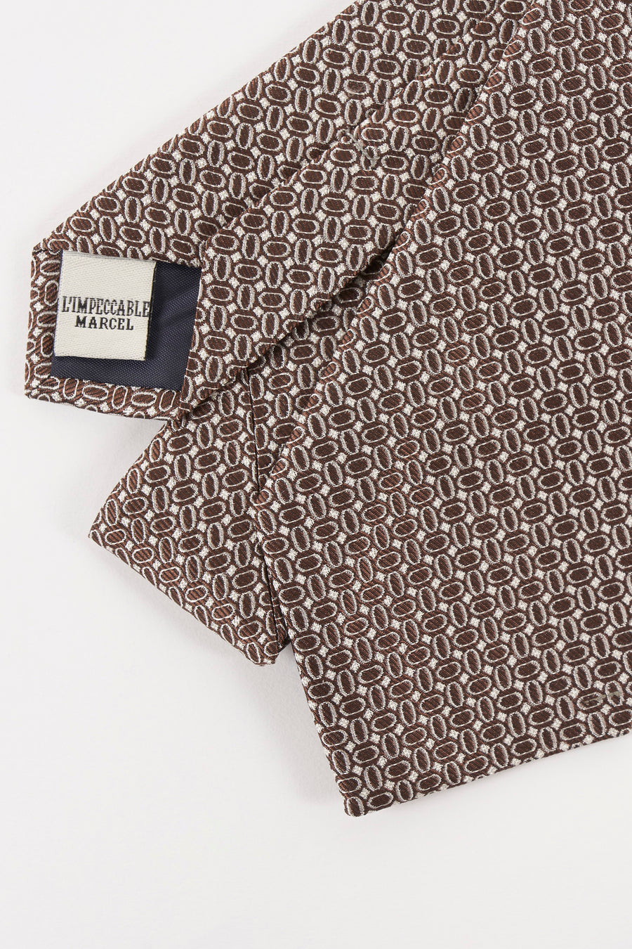 Cravate marron, de Le Fabuleux Marcel de Bruxelles, avec motif géométrique répétitif.
