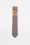 Cravate marron à motifs géométriques van Le Fabuleux Marcel de Bruxelles, présentée sur fond blanc.
