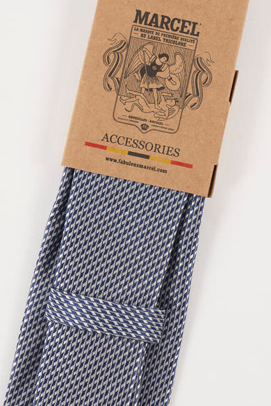 Blauwe pied-de-poule stropdas van Le Fabuleux Marcel de Bruxelles, gepresenteerd op de kartonnen verpakking.