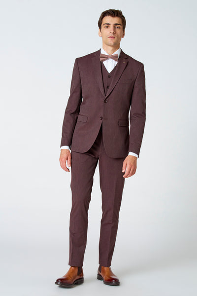Blazer brun de Le Fabuleux Marcel de Bruxelles, avec gilet, porté avec chemise blanche et nœud papillon à motifs.