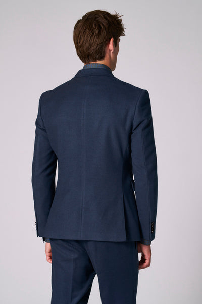 Marineblauwe blazer van Le Fabuleux Marcel de Bruxelles, met getailleerde pasvorm en nette afwerking, van achteren gezien.