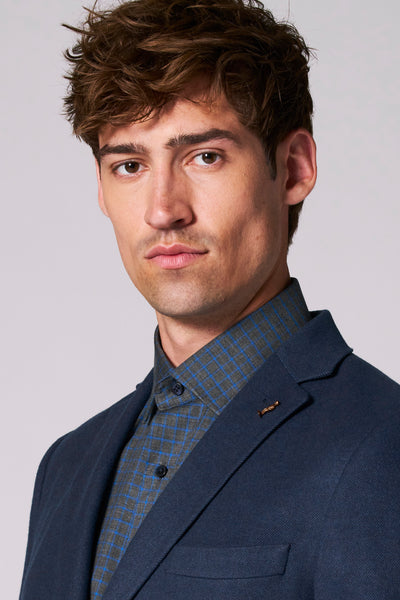 Blazer blauw van Le Fabuleux Marcel de Bruxelles, met een geruit overhemd, gedragen door een man.