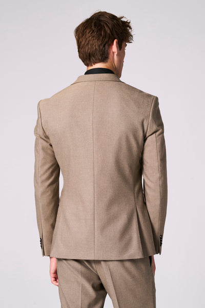 Beige blazer van Le Fabuleux Marcel de Bruxelles, achterzijde, met bijpassende broek en zwarte coltrui.