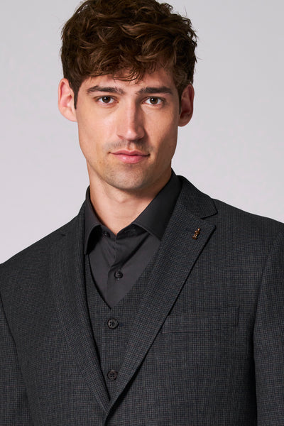 Bruine blazer van Le Fabuleux Marcel uit Brussel, met discreet patroon en versierd met een decoratieve broche.