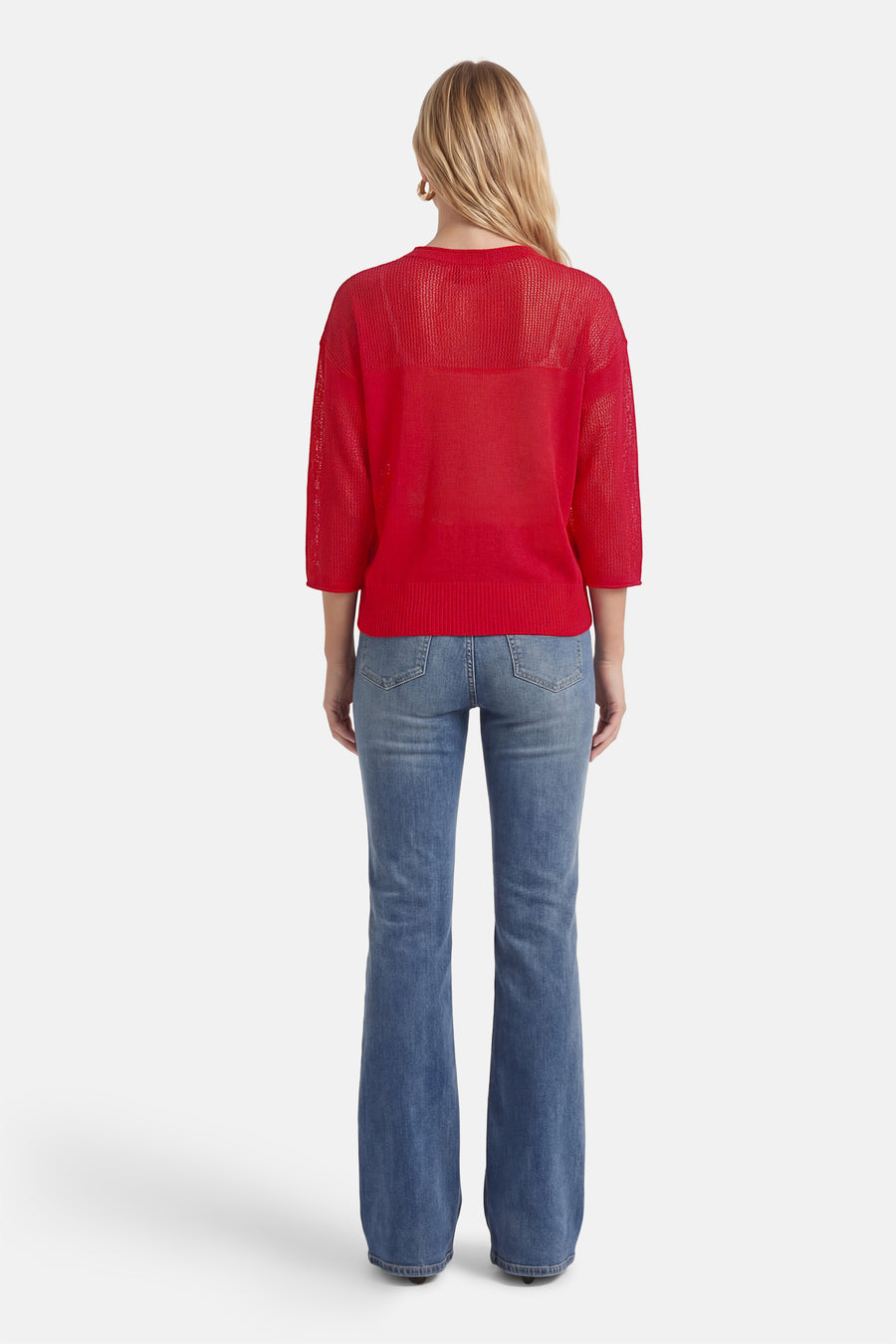 Sweat rouge à col rond par ADORE, porté avec un jean bleu évasé, vue de dos.