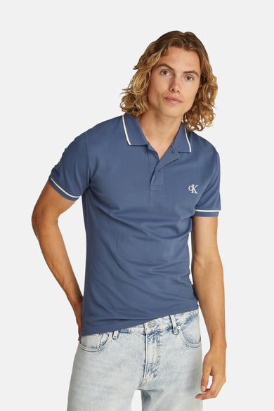 Blauw poloshirt van piquébreiwerk van Calvin Klein, met geborduurd logo en witte gestreepte afwerkingen.