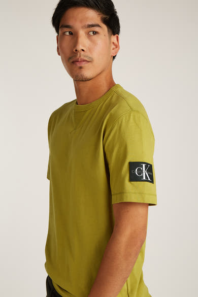 Okerkleurig T-shirt met korte mouwen van Calvin Klein, met logopatch op de mouw.