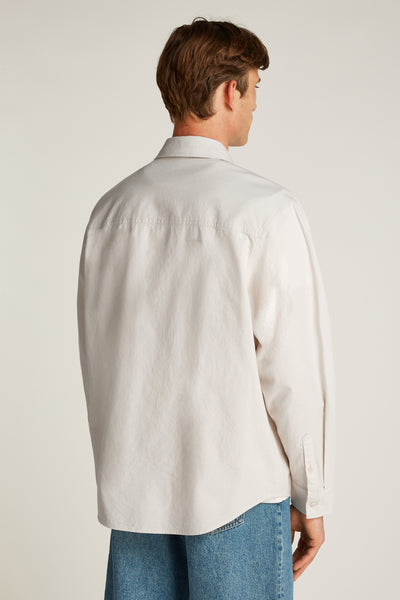 Chemise à manches longues écrue de Calvin Klein, vue de dos, portée avec un jean bleu.