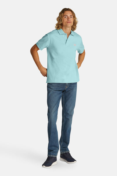 Turquoise poloshirt met korte mouwen van Calvin Klein, gedragen met een spijkerbroek en sneakers.