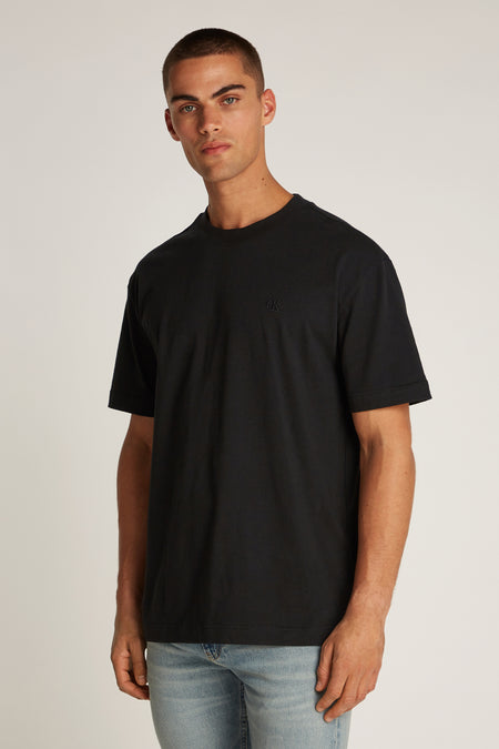 Zwart T-shirt met korte mouwen van Calvin Klein, gedragen met een lichtblauwe spijkerbroek
