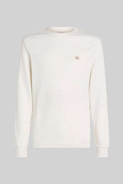 Ecru T-shirt met lange mouwen van Calvin Klein, met een subtiel wafelpatroon en een discreet logo op de borst.
