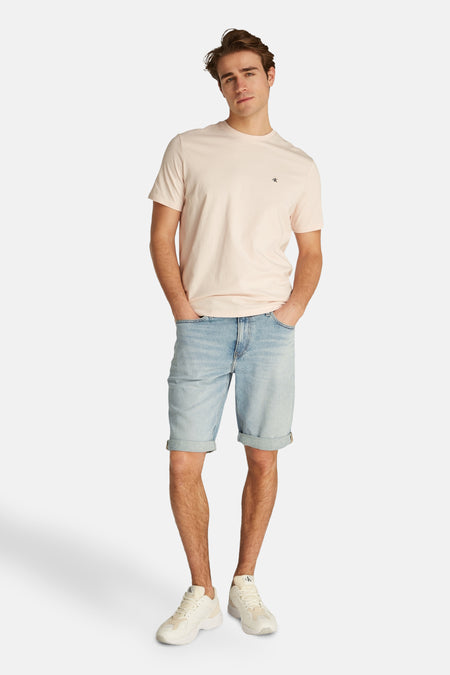 Short en jeans denim bleu clair de Calvin Klein, avec ourlets roulés et style décontracté.