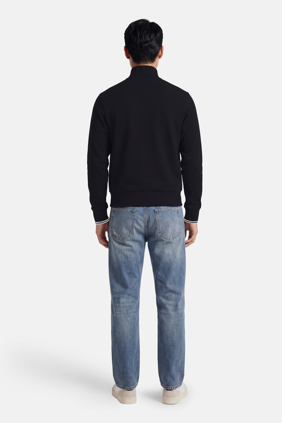 Black sleeveless sweat gilet with ribbed cuffs and collar, back view, worn with light blue jeans and white sneakers
