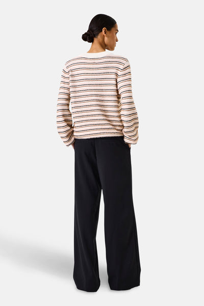 Pull à col rond multicolore de GARCIA, à rayures horizontales roses, noires et marron, porté avec un pantalon noir.