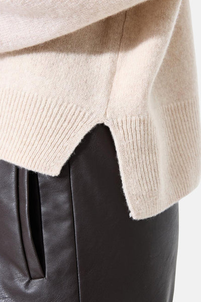 Ecru coltrui van GARCIA, splitdetail op een bruine leren broek.