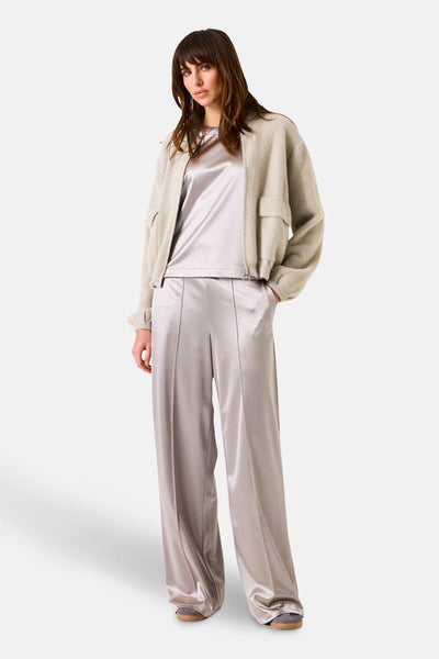 Gilet beige de GARCIA avec poches plaquées et fermeture éclair, porté sur un ensemble satiné ton sur ton.