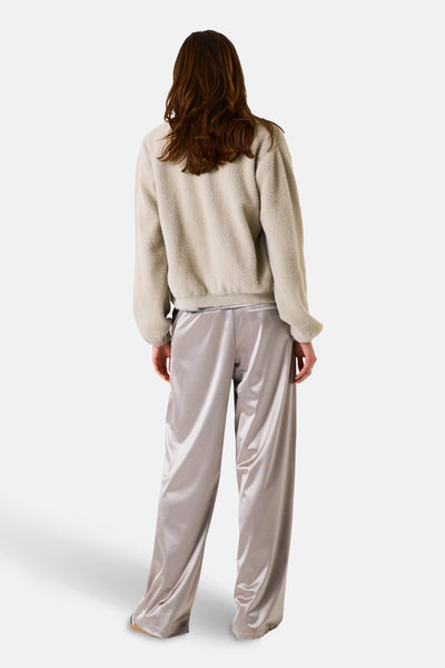 Gilet beige par GARCIA, avec une texture douce et une coupe décontractée, porté avec un pantalon satiné.