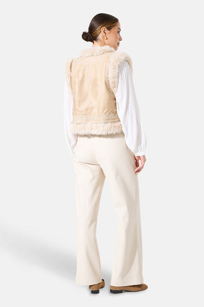 Beige jas van GARCIA met imitatiebontrand, gedragen met een witte blouse en een crèmekleurige broek.