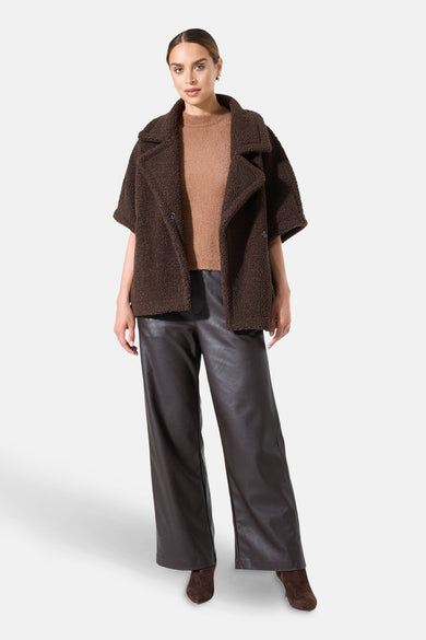Korte bruine fauxbontjas van GARCIA, met een bruine trui en een bruine imitatielederen broek.