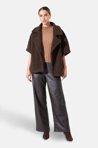 Korte bruine fauxbontjas van GARCIA, met een bruine trui en een bruine imitatielederen broek.