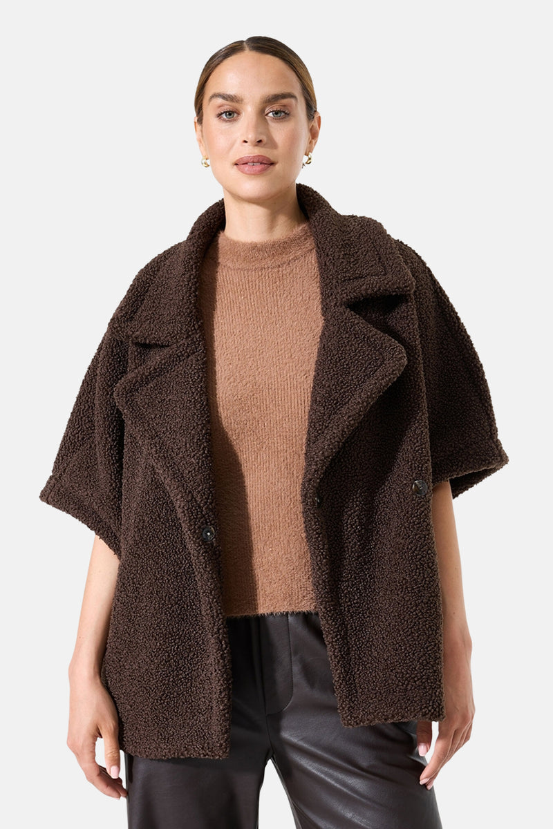 Bruine fauxbontjas van GARCIA, met een beige trui en een leren broek.