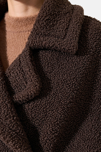 Veste en teddy marron de GARCIA, avec un col châle texturé, portée sur un pull en maille camel.
