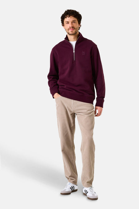 Paarse trui met opstaande kraag van GARCIA, met ritssluiting en gedragen met een corduroy broek en witte sneakers.