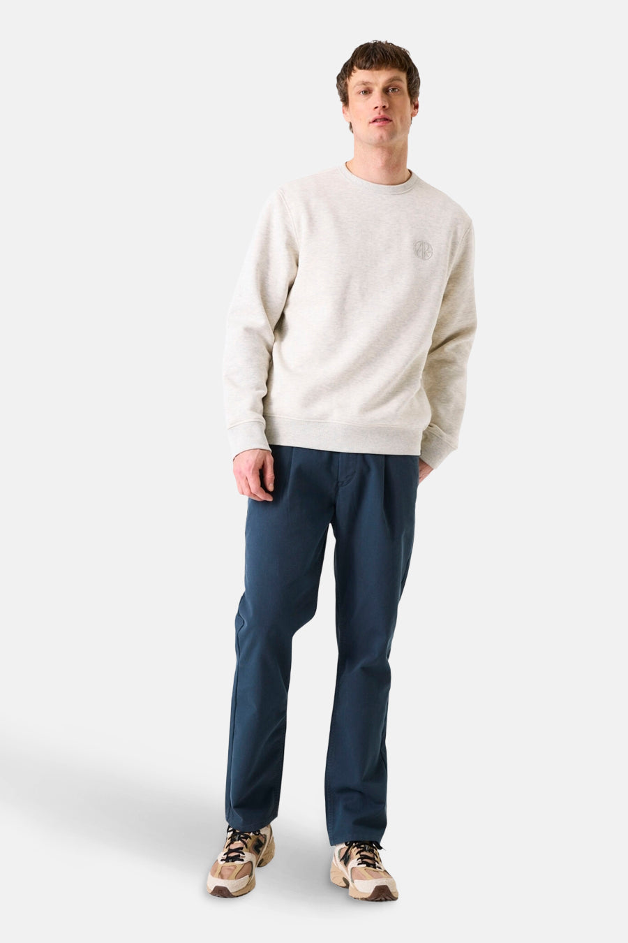 Baksteenrode trui van GARCIA, met een klein logo op de borst en gedragen met een marineblauwe broek.