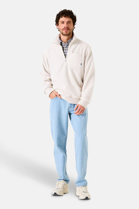 Ecru fleece van GARCIA, met borstzak, gedragen over een geruit overhemd en een lichtblauwe, uitgewassen spijkerbroek.