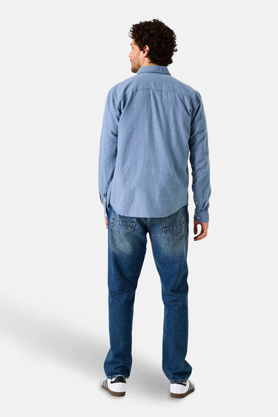 Chemise à manches longues bleue de GARCIA, vue de dos, portée avec un jean et des baskets blanches.