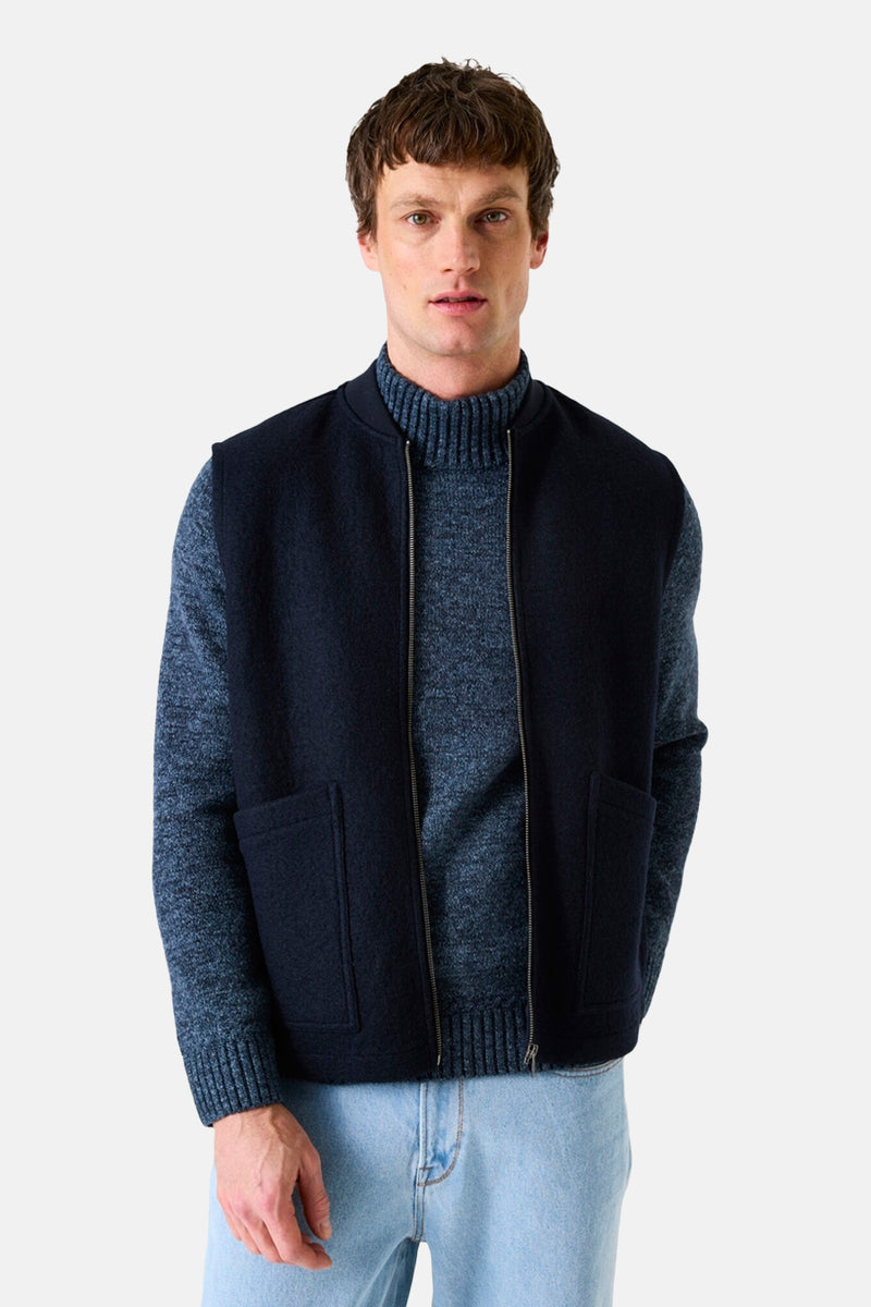 Blauwe bodywarmer van GARCIA, met ritssluiting en opgestikte zakken, gedragen over een coltrui.