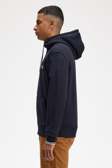 Marineblauwe hoodie van FRED PERRY, met trekkoord en kangoeroezak, gedragen met een bruine broek.