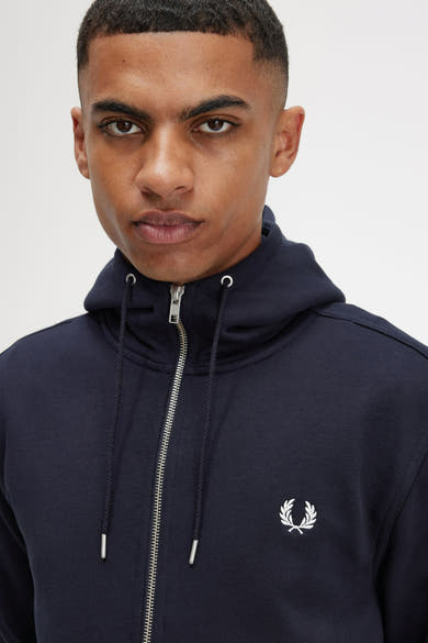 Marineblauwe bodywarmer van Fred Perry, met zilveren ritssluiting en geborduurd logo.