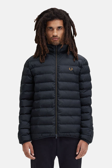 Zwarte regenjas van FRED PERRY, gewatteerd met ritssluiting en gouden logo, gedragen met een zwarte broek.
