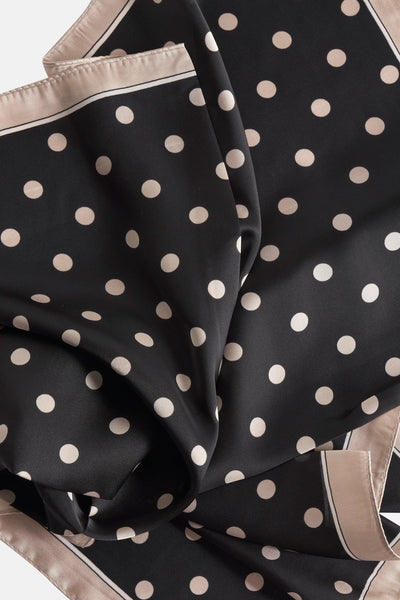 Foulard noir à pois crème d'Access®, avec bordure contrastante beige et noire.