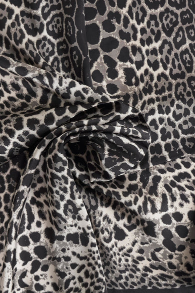 Foulard noir de Access®, motif léopard gris et noir, avec un effet drapé.