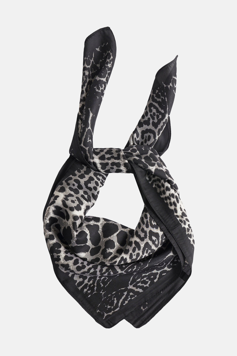 Foulard noir, de Access®, avec un motif léopard gris et noir, noué et disposé verticalement.