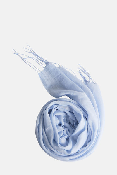 Foulard bleu d'Access®, enroulé avec des franges décoratives sur un fond uni.