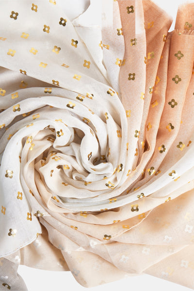 Foulard beige, Access®, à motif floral doré, enroulé en spirale.