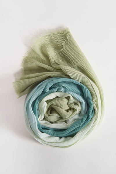 Foulard vert enroulé de Access®, avec un dégradé de couleurs allant du vert au bleu.