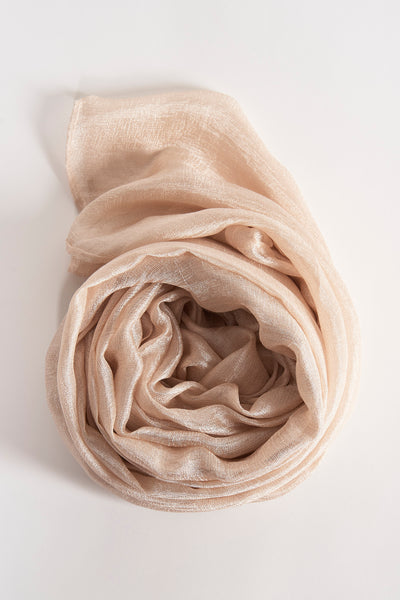 Foulard beige Access® enroulé, texture légère et brillante, sur fond uni clair.
