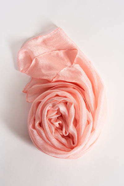 Foulard rose Access®, drapé en forme de rose sur un fond blanc uni.