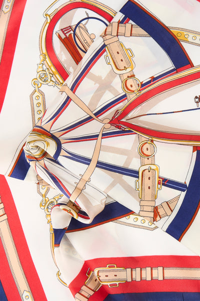 Foulard multicolore par Access®, motif équestre avec boucles, chaînes et rayures rouge, blanc et bleu marine.
