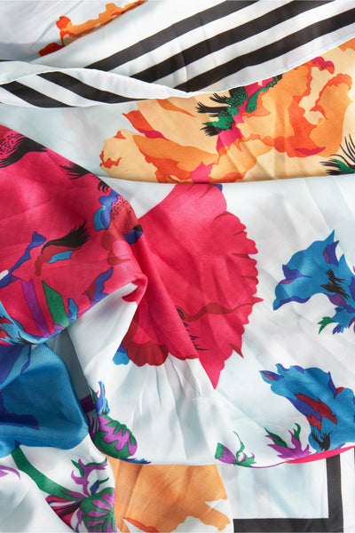 Foulard bleu Access®, à motifs floraux multicolores avec des rayures noires et blanches.