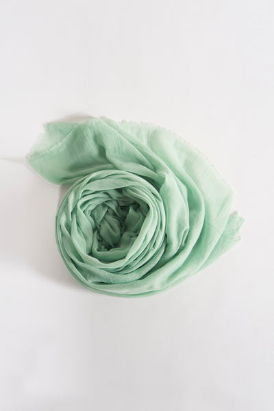 Groene sjaal van Access® met lichte textuur en delicate franjes op een effen witte achtergrond.