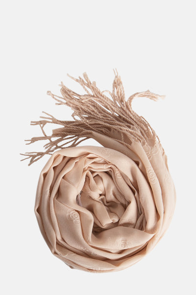 Foulard beige enroulé par Access® avec des franges torsadées et un motif floral subtil.