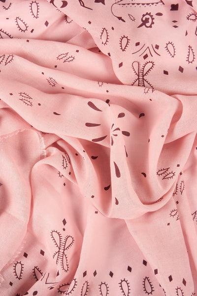 Foulard rose de Access® avec motifs fantaisie marron foncé, tissu légèrement froissé.